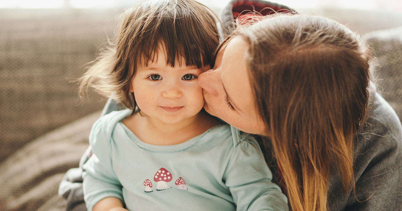 mom kissing a child on the cheek