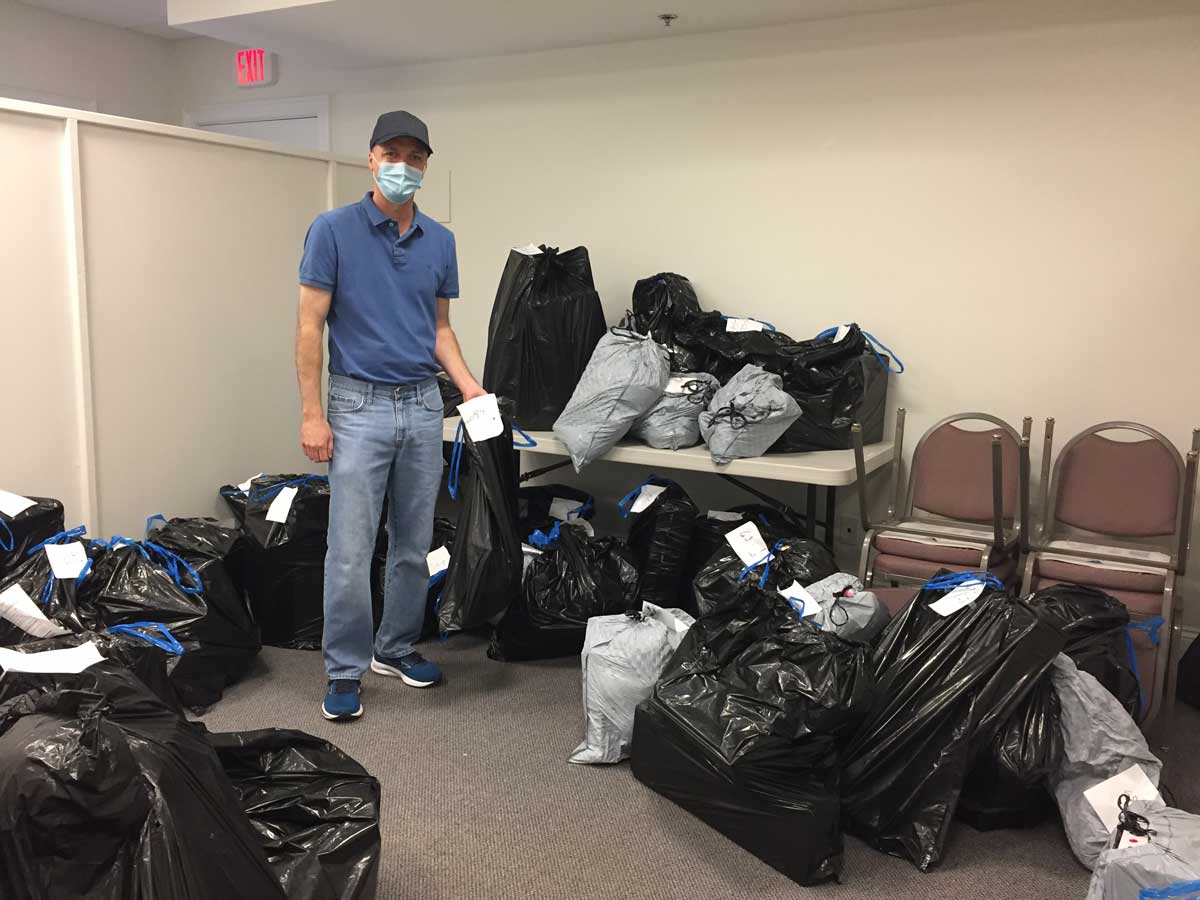 CACCI Volunteer standing in room full of bags of toys